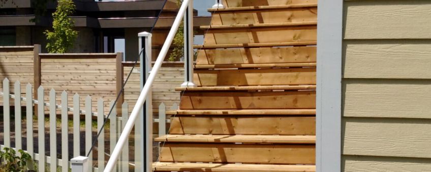 Frameless glass railing with white pipe railing on an outdoor staircase