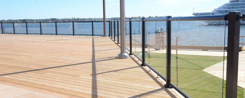 Large outdoor deck space with surface mount glass railings and black aluminum top and bottom rails